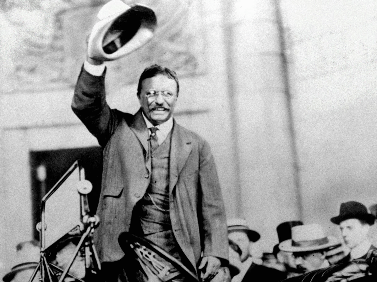 Black-and-white portrait of Theodore Roosevelt with a sharp, intense gaze, reflecting his strong personality and legendary memory.