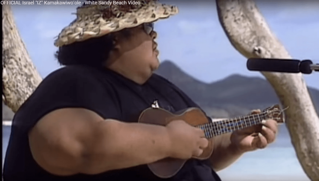 Israel Kamakawiwo'ole playing ukulele in iconic Hawaiian style
