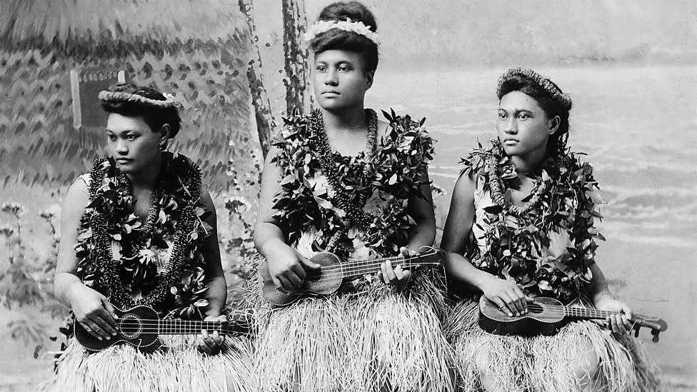 Vintage Hawaiian ukulele on wooden table, symbolizing the history and global spread of the instrument.